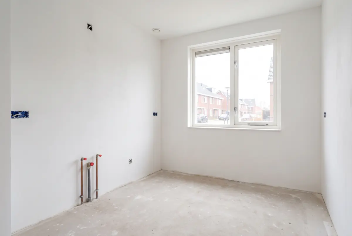 Een lege keuken zonder meubels, klaar om opnieuw in te richten